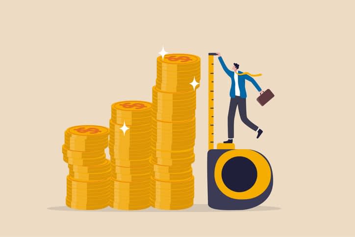 businessman investor using measuring tape to measure money coins stack height