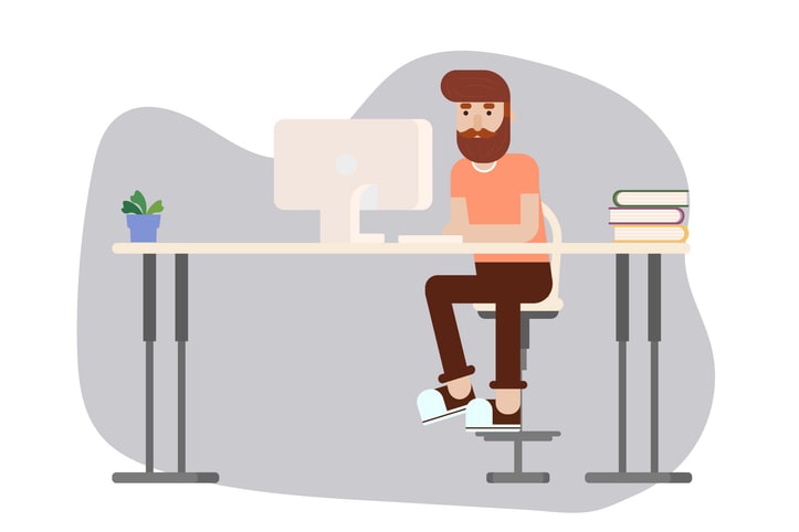 Young Man Sitting at the Desk and Using Keyboard and PC